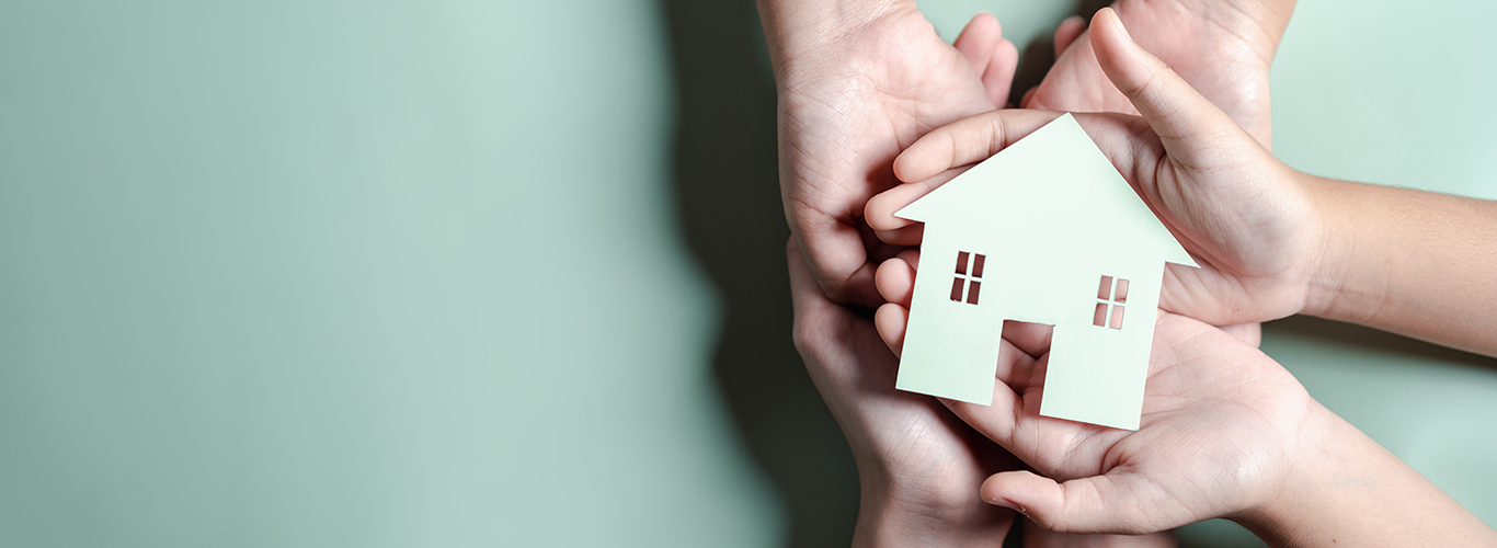 Hands holding wooden house, family home, homeless housing, mortgage crisis and home protecting insurance, international day of families, foster home care, family day care, stay home concept